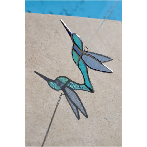 Colorful handmade stained glass hummingbird window suncatcher catching sunlight, home decoration