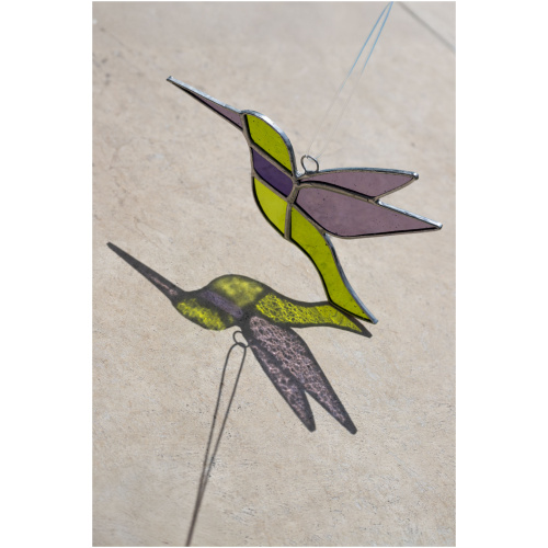 Colorful handmade stained glass hummingbird window suncatcher catching sunlight, home decoration