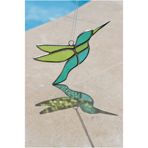 Colorful handmade stained glass hummingbird window suncatcher catching sunlight, home decoration