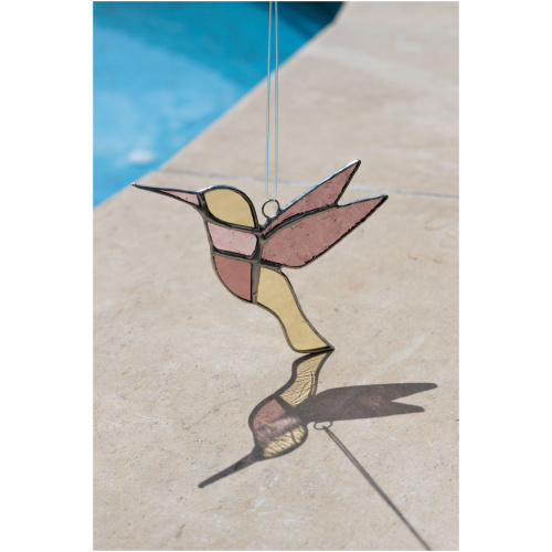 Colorful handmade stained glass hummingbird window suncatcher catching sunlight, home decoration