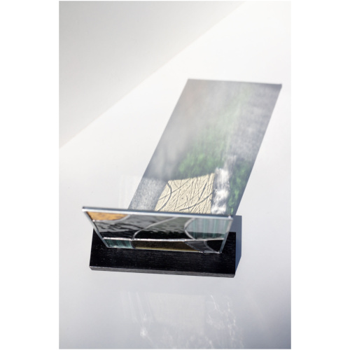 Abstract modern stained glass panel featuring textured and smooth glass elements, mounted on a minimalist wood block stand