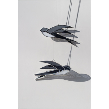 Handcrafted stained glass swallow sun catcher casting a graceful bird-shaped shadow