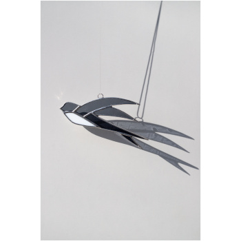 Handcrafted stained glass swallow sun catcher casting a graceful bird-shaped shadow